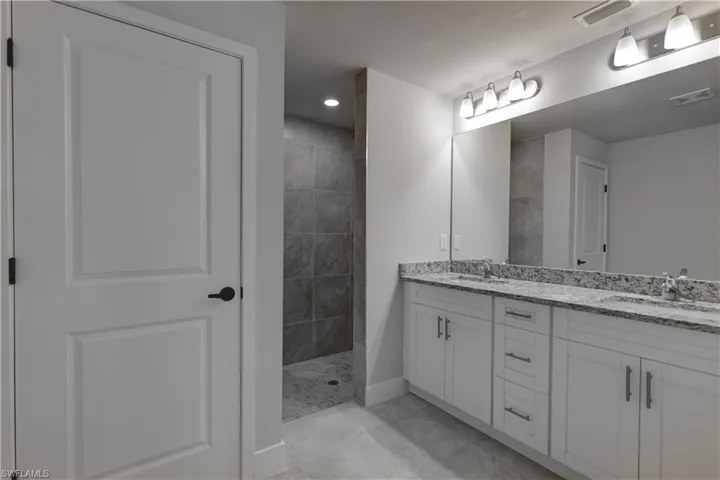 Bathroom with dual vanity and tile patterned floors