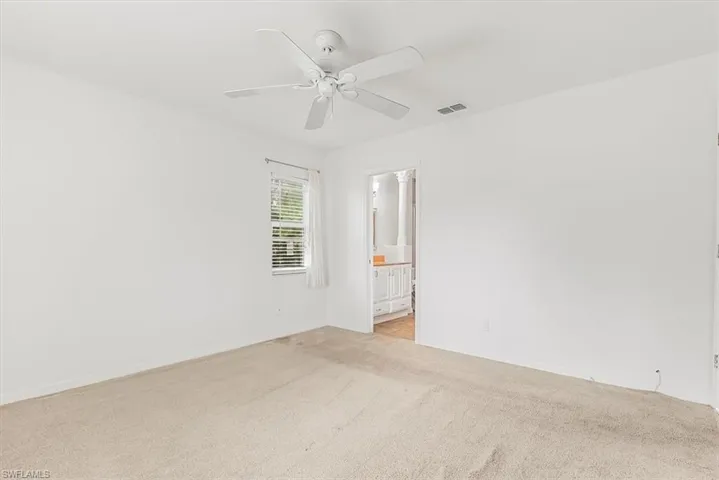 Spare room featuring light carpet and ceiling fan