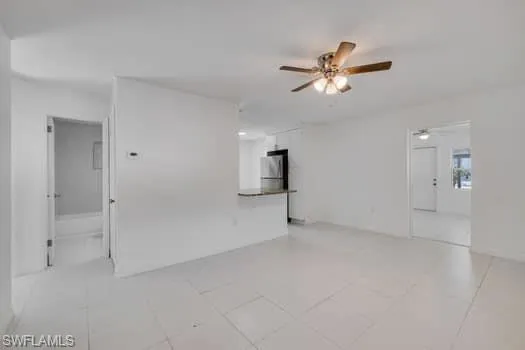 Unfurnished room featuring a ceiling fan and light tile patterned flooring