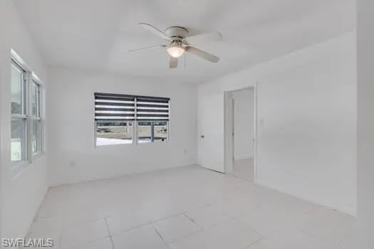 Spare room featuring a ceiling fan and light tile patterned floors