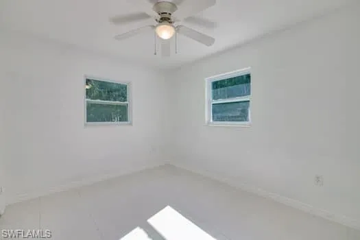 Empty room with ceiling fan and tile patterned floors