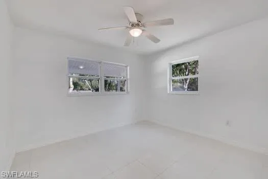 Empty room featuring ceiling fan and light tile patterned floors