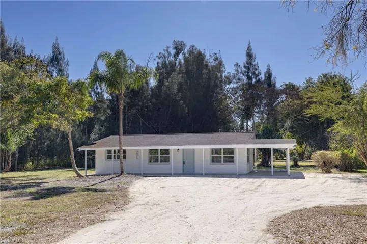 Ranch-style house featuring driveway and covered porch