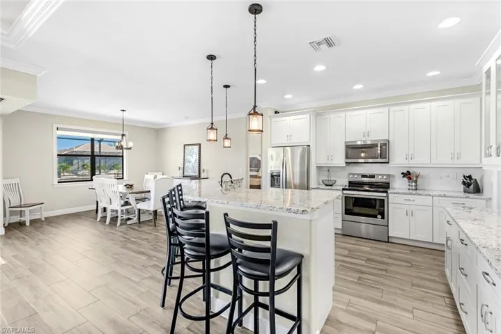 Kitchen with tray ceiling and breakfast bar with Pendant lighting.