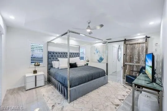 Bedroom featuring a barn door and ceiling fan