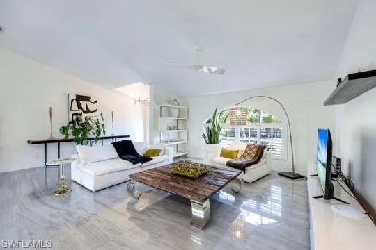 Living room featuring ceiling fan and vaulted ceiling