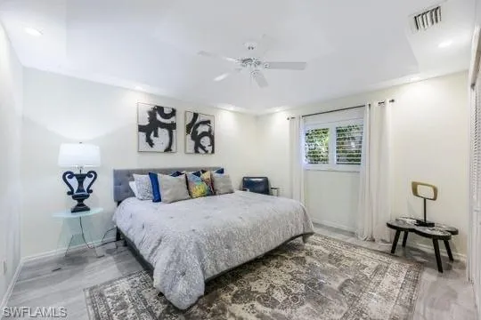 Bedroom with ceiling fan and hardwood / wood-style floors