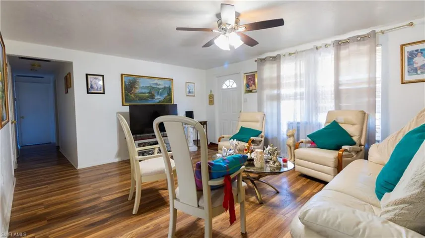 Living room featuring ceiling fan and dark hardwood / wood-style flooring