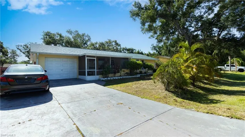 Ranch-style home featuring a garage and a front lawn