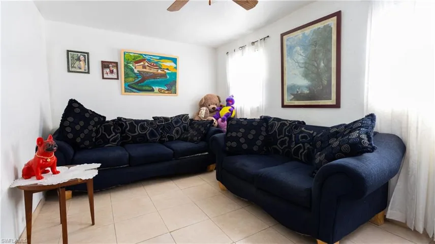 Living room featuring ceiling fan and light tile floors