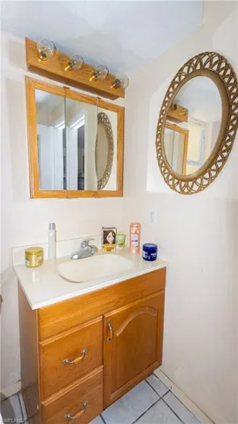 Bathroom featuring vanity with extensive cabinet space and tile floors