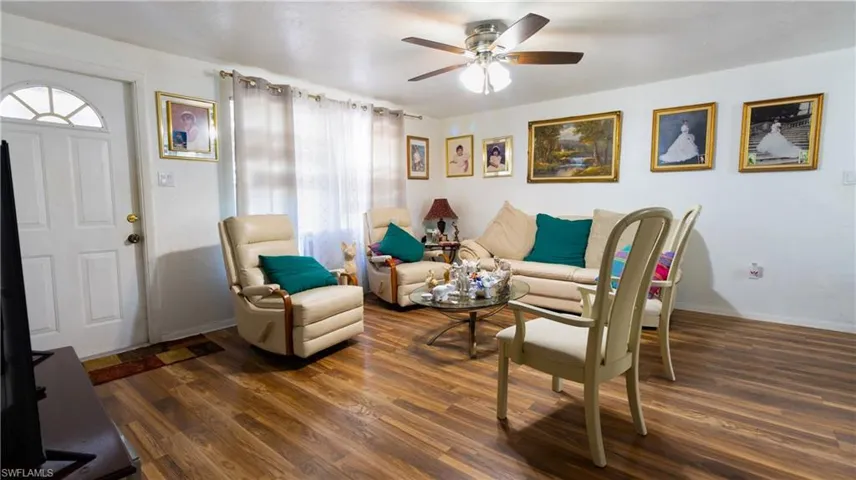 Living room with ceiling fan and dark hardwood / wood-style flooring