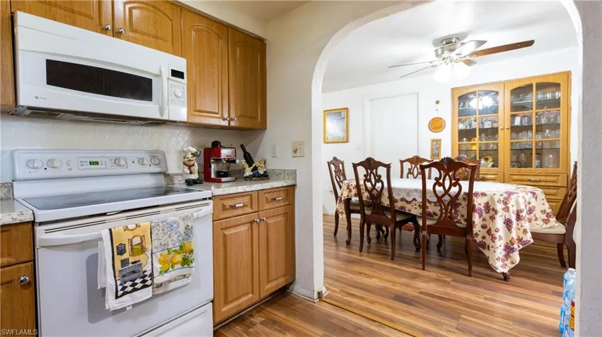 Kitchen with white appliances, ceiling fan, and hardwood / wood-style floors