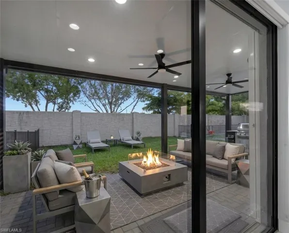 Virtually Staged* Expansive covered patio featuring recessed lighting, dual ceiling fans, and a built-in fire pit
