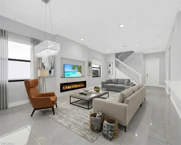 Virtually Staged Open-concept living space featuring sleek tile flooring, a contemporary linear fireplace, and recessed lighting