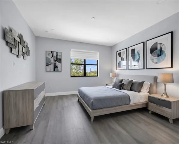 Virtually Staged*Bedroom featuring wood-finish flooring, recessed ceiling lighting, a large window with roller shades, and a neutral color palette