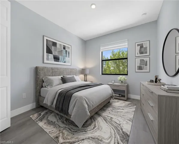 Virtually Staged*Well-proportioned bedroom featuring wood-finish flooring, a window with exterior views, recessed lighting, baseboard trim, and light gray walls