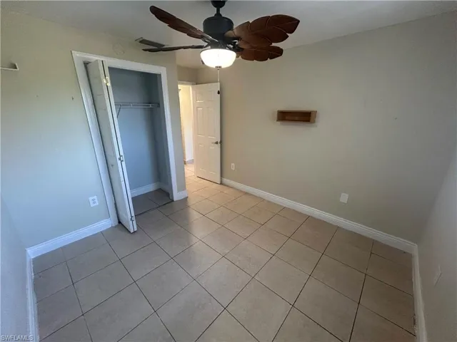 Unfurnished bedroom featuring ceiling fan, a closet, and light tile patterned floors