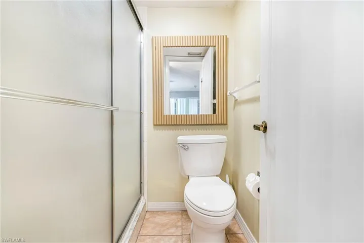 Full bath with light tile patterned flooring and a shower stall