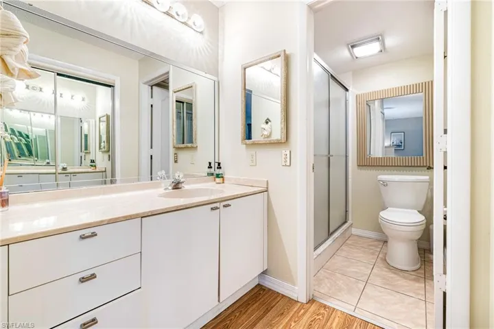 Full bathroom featuring vanity, a shower stall, and light wood-type flooring