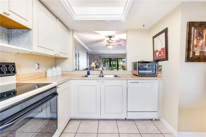 Kitchen featuring range with electric cooktop, light countertops, white cabinets, and ornamental molding