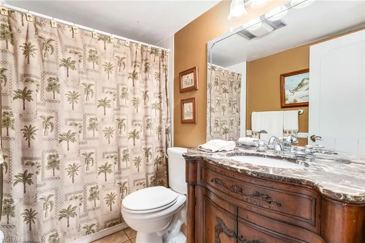 Bathroom featuring vanity, tile patterned floors, and curtained shower