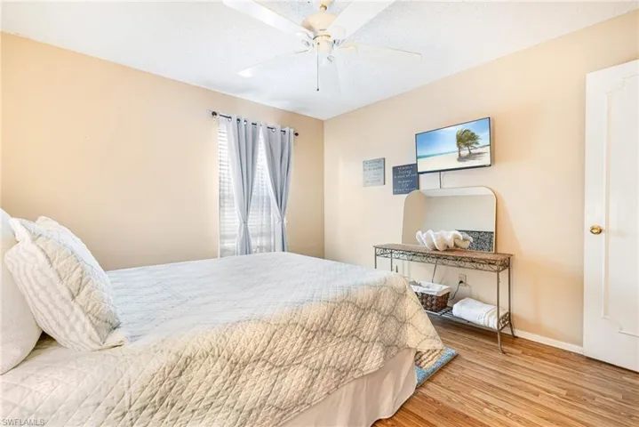 Bedroom with light wood-style flooring, a textured ceiling, and ceiling fan