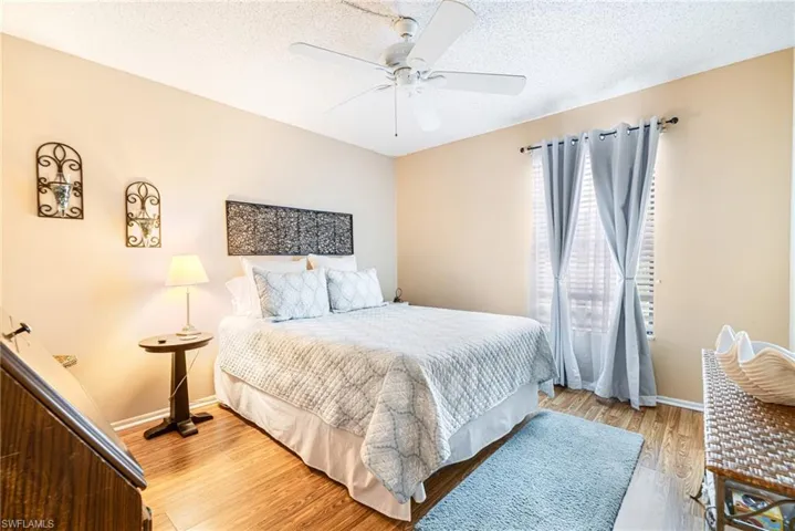 Bedroom with wood finished floors, a textured ceiling, and ceiling fan
