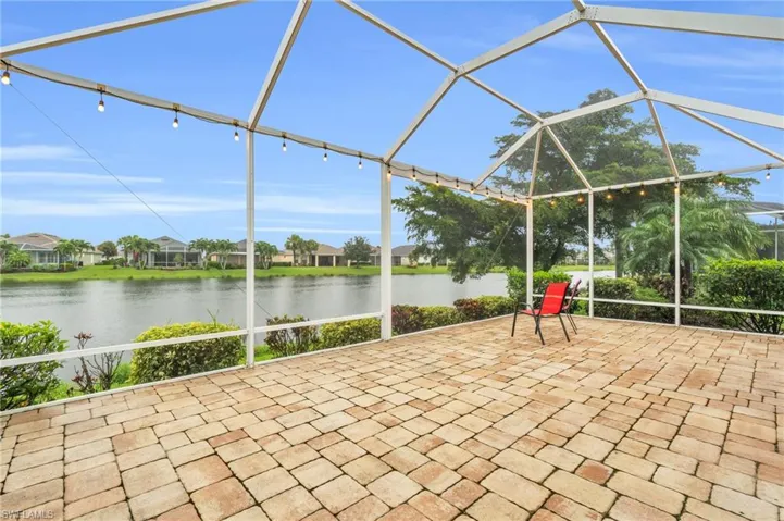View of patio / terrace featuring a water view and glass enclosure
