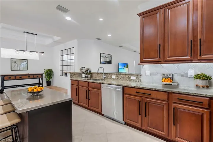 Kitchen featuring a breakfast bar, sink, kitchen peninsula, decorative light fixtures, and dishwasher