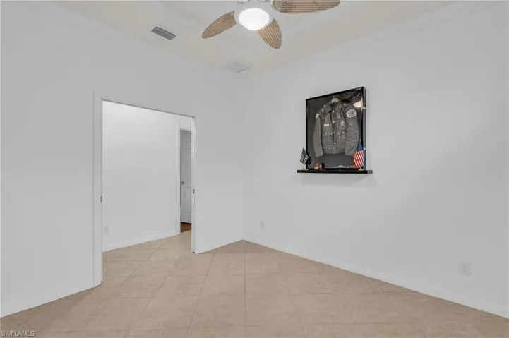 Unfurnished room with crown molding, light tile patterned flooring, and ceiling fan