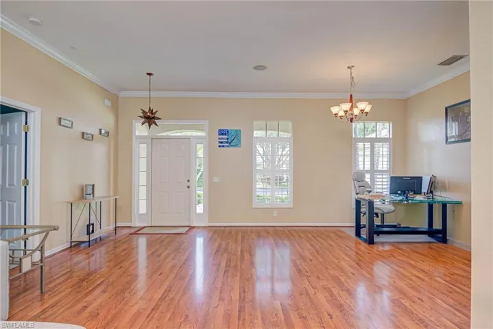 Looking at entry and front door and formal dining space, currently being used as an office.