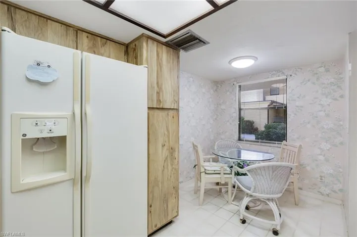 Kitchen featuring tile flooring and white refrigerator with ice dispenser