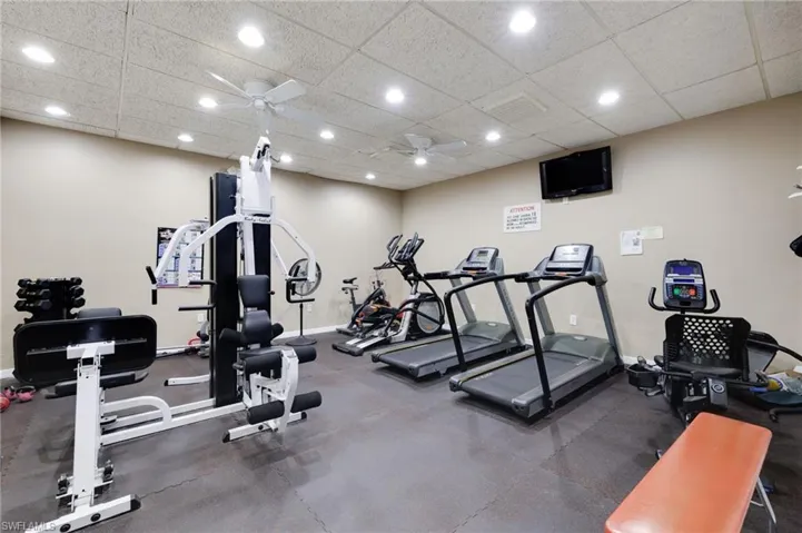 Workout area with a paneled ceiling and ceiling fan