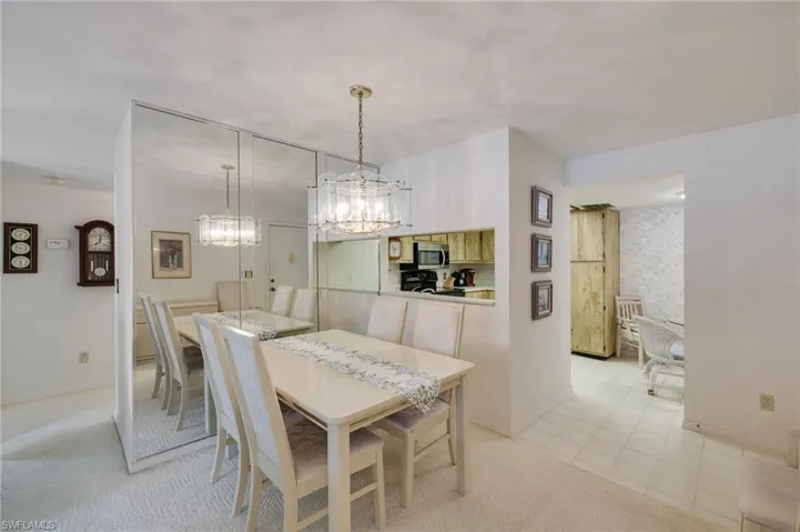 Dining area featuring light carpet and a chandelier