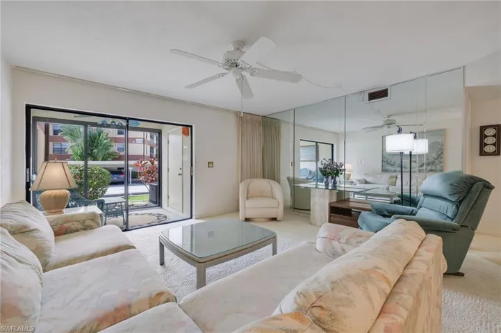 Carpeted living room with ceiling fan