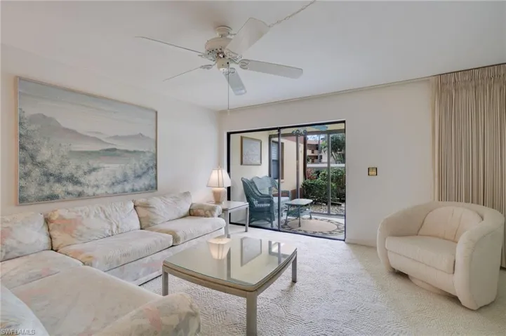 Carpeted living room with ceiling fan