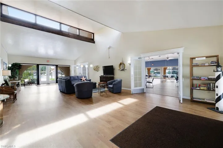 Living room featuring high vaulted ceiling, french doors, and wood-type flooring