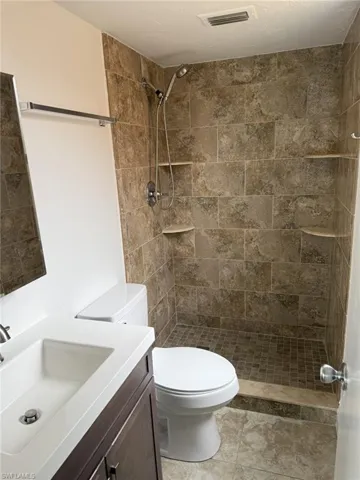 Bathroom featuring vanity and a tile shower