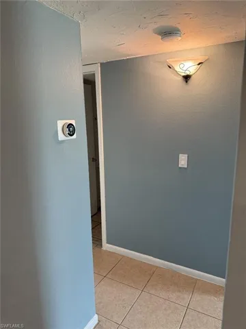 Corridor with light tile patterned floors and baseboards
