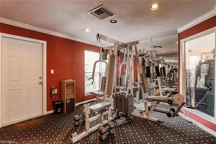 Exercise room featuring carpet floors, ornamental molding, and recessed lighting