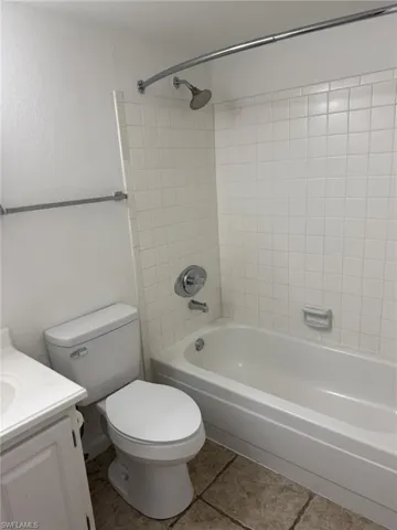 Full bath with vanity, shower / washtub combination, and tile patterned flooring