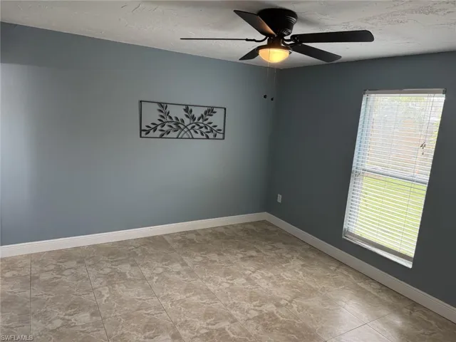 Spare room featuring a ceiling fan and a textured ceiling