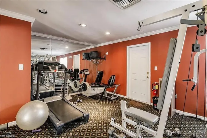 Exercise room featuring crown molding, recessed lighting, and carpet floors
