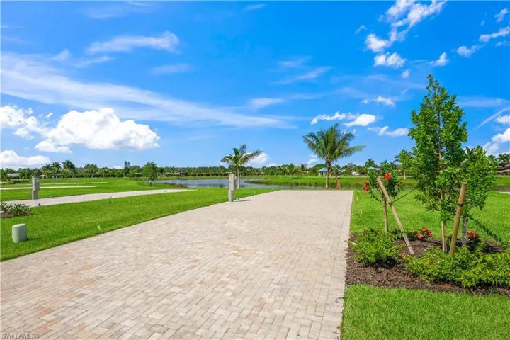 View of property's community featuring a lawn and a water view