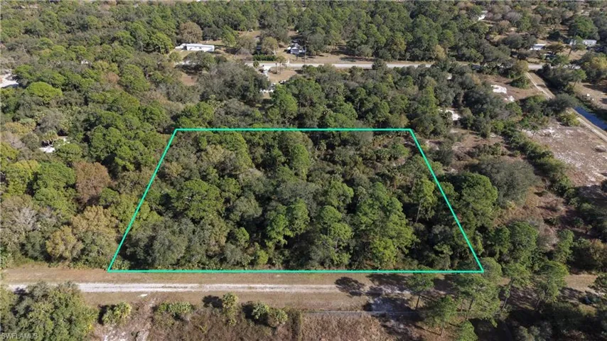 Aerial view of property's location featuring property boundaries highlighted and a forest