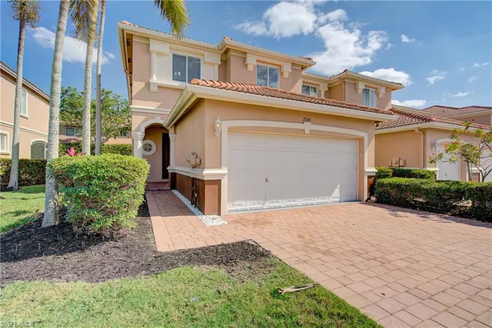 Mediterranean / spanish home with decorative driveway, an attached garage, a tile roof, and stucco siding