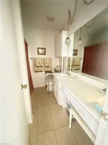 Hall Bathroom featuring toilet, vanity, and tile patterned flooring