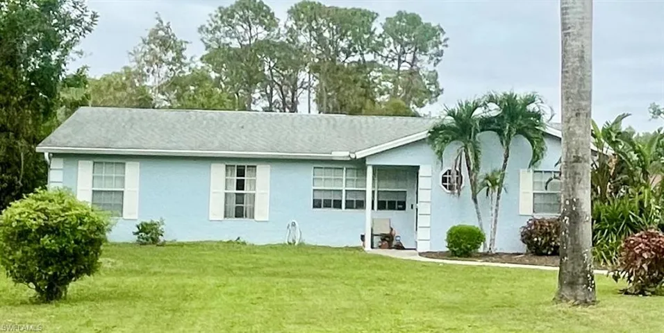 View of front of home featuring a front lawn and a garage