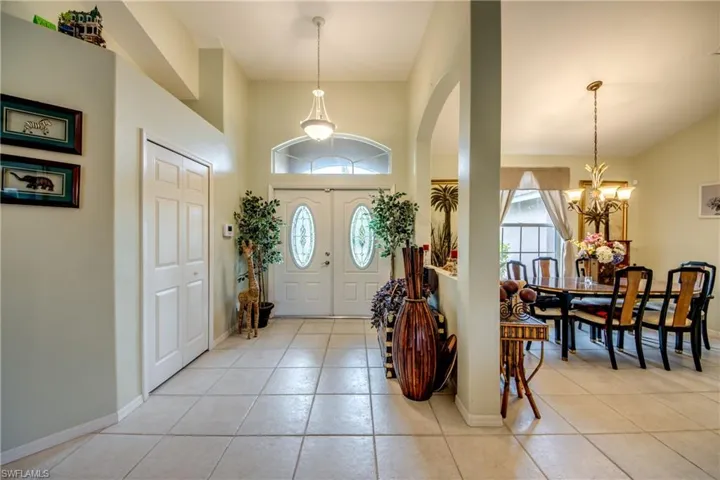 Tiled entrance foyer featuring a notable chandelier and spacious closet.